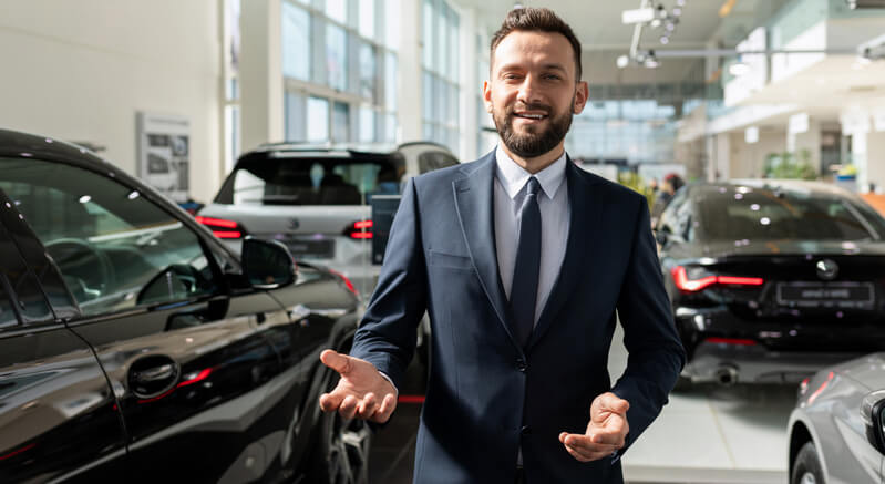 An automotive professional walking around the dealer showroom after completing his automotive training