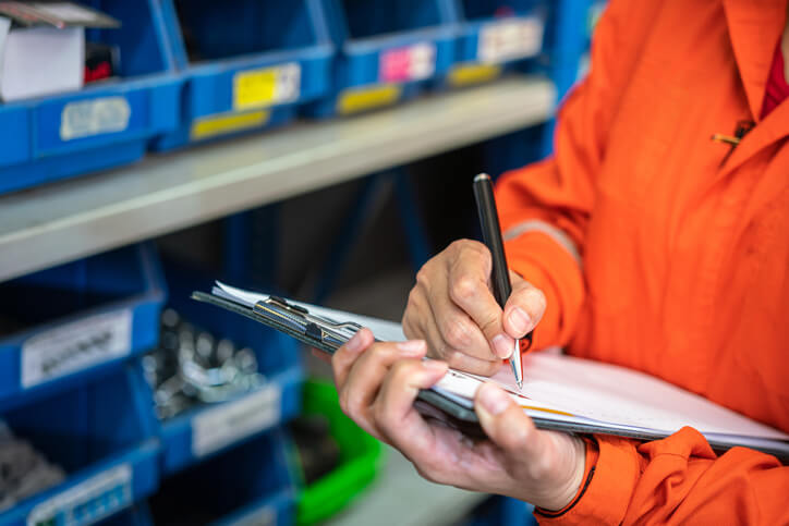 An auto parts specialist checking inventory in a warehouse after completing their auto parts training