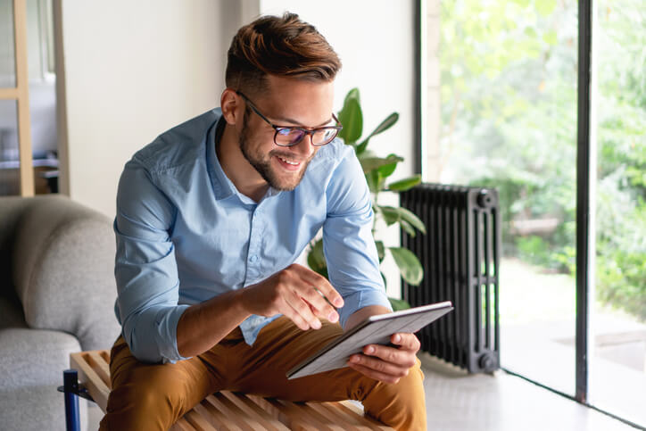 An automotive training grad looking at a car from home on his tablet