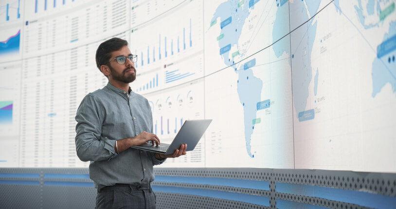 A male dispatcher analyzing data on a big screen after completing his dispatch training