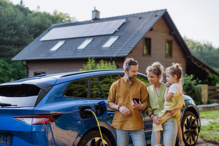 An automotive school grad charging an EV at home with family