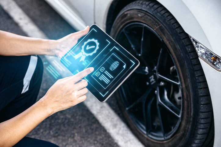 A mechanic analyzing data from digital maintenance software on his tablet after completing auto mechanic school.