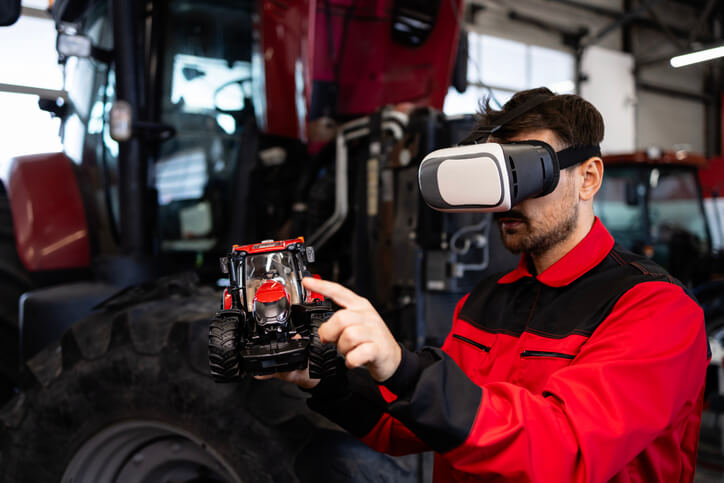 A male mechanic wearing virtual reality glasses in an auto repair shop after completing his auto mechanic training