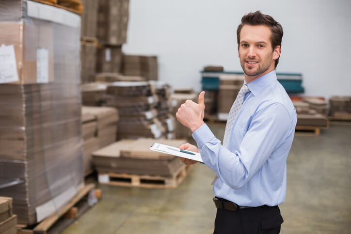 A warehouse manager checking inventory records after completing his auto parts training.