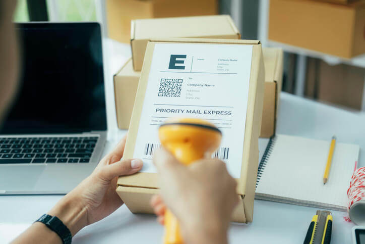 An auto parts grad putting a shipping label on a parcel