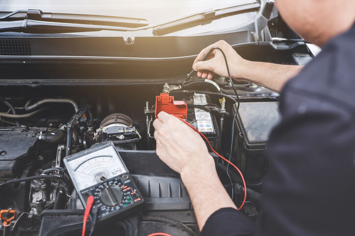 An automotive training student diagnosing a hybrid vehicle