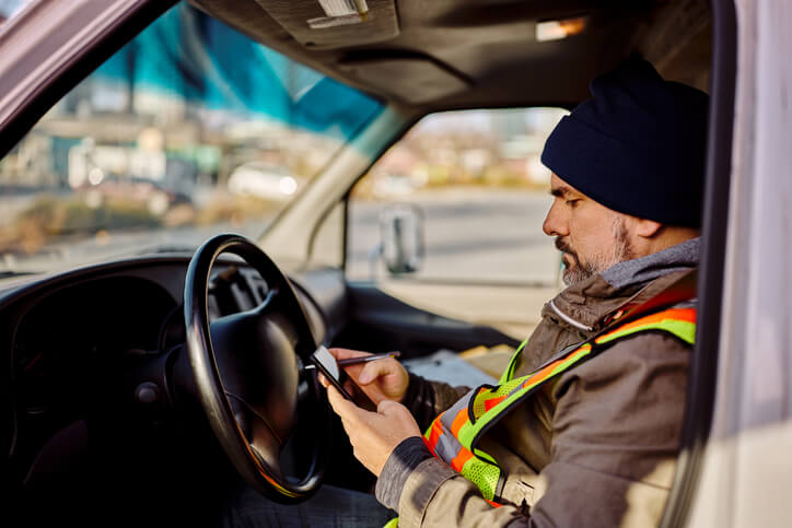 A professional parts driver using a GPS device to plan a direct route to the next repair shop after completing his auto parts training