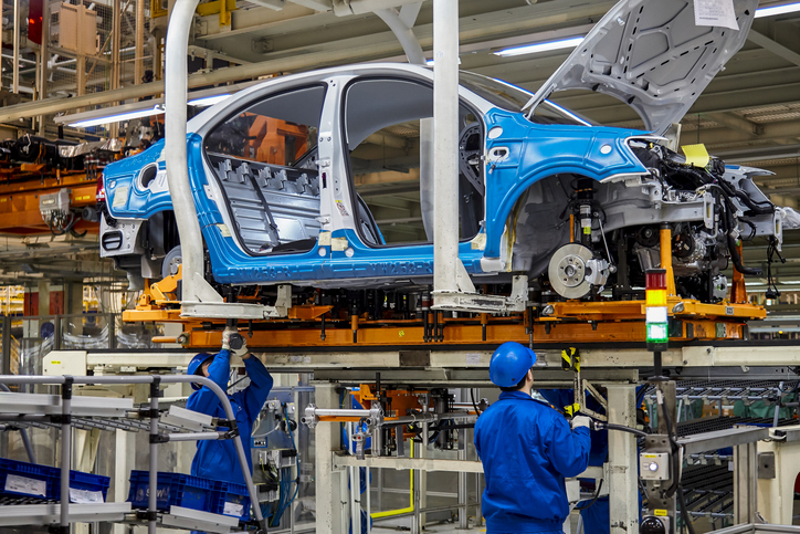 Workers assembling auto parts at a manufacturing plant