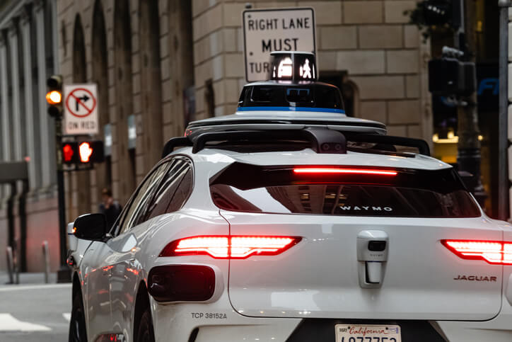 A close-up of a sleek autonomous vehicle navigating a city street, highlighting the latest advancements in auto tech.