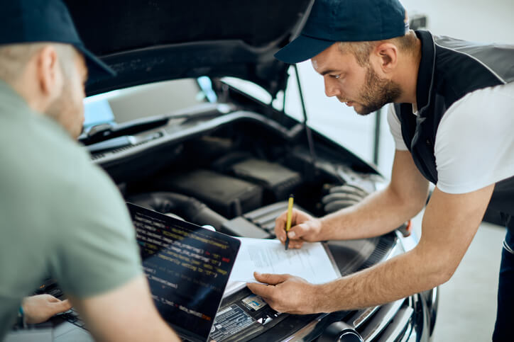 A mechanic reviewing cybersecurity features in an EV after completing his hybrid and electrical mechanic training