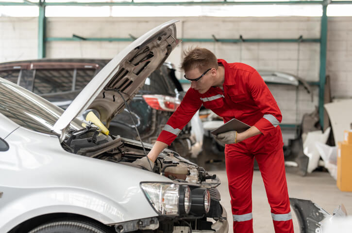 An automotive school student examines an electric vehicle.