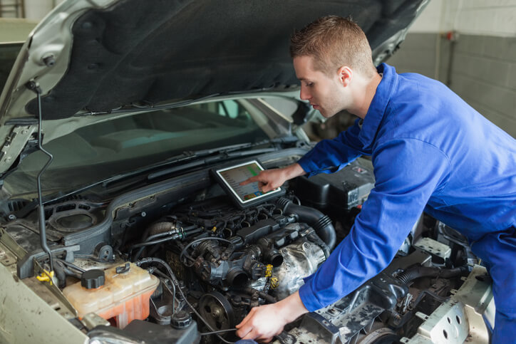 An EV technician working on a vehicle’s digital systems after automotive school