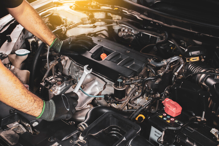 Auto mechanic working on a hybrid vehicle after completing his hybrid and electrical mechanic training